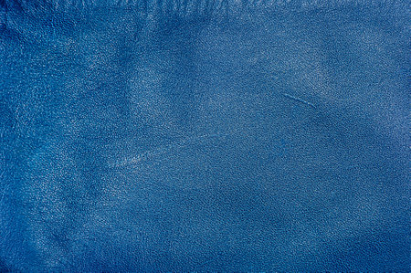 Macro photo of genuine leather dyed in blue. Blue leather background with scratches.の写真素材