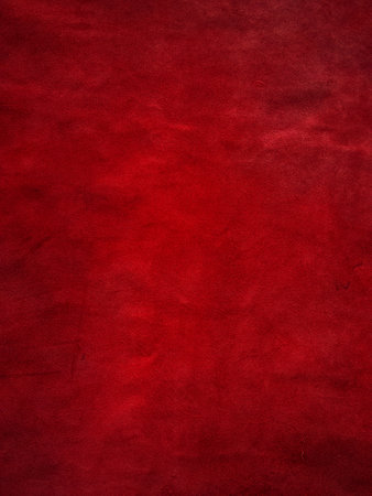Dark red matte background of suede fabric, closeup. Vertical red velvet background, leatherの写真素材