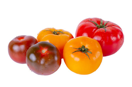 Ripe tomatoes of yellow, black and red color with water drops isolated on white background.の写真素材