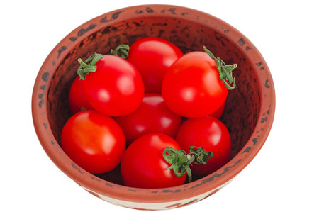 Red tomatoes in a clay brown bowl isolate on a white background. Vegetables, tomatoの写真素材