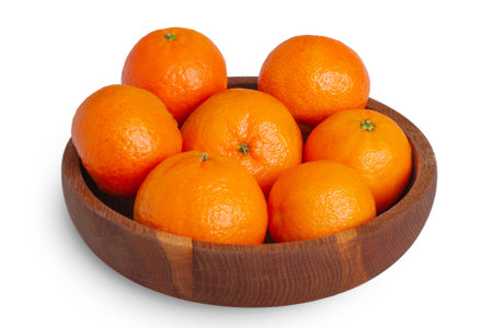 Tangerines in a wooden plate isolate on a white background. Fruits, citrus fruits.の写真素材