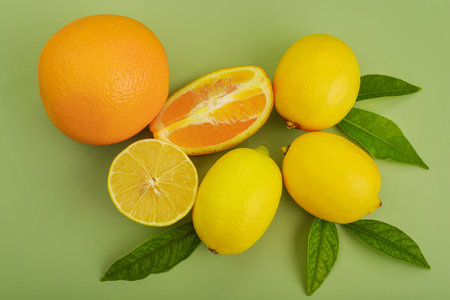 Citrus fruits. Orange oranges and yellow lemons on a green background.の写真素材