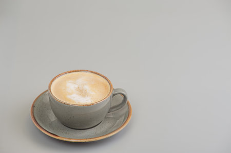 A cup of cappuccino with a saucer on a gray backgroundの写真素材