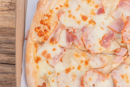 Meat pizza in a box on a wooden backgroundの写真素材