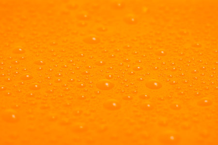Texture of water drops on orange plastic
