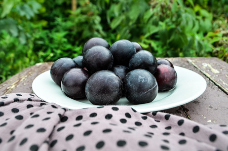 Fresh plums on old wooden tableの写真素材