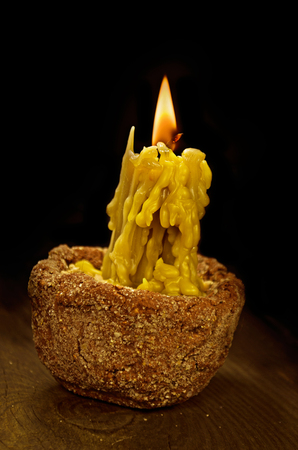 Old white candles on black background  and on wooden tableの写真素材