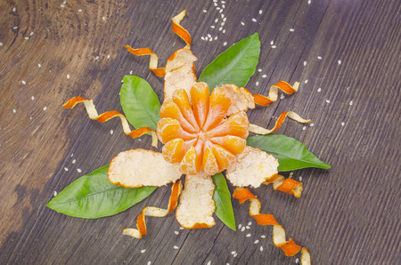 Orange radial peeled like a  flower on wooden  background.の写真素材