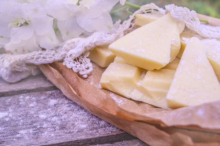 Pieces of cocoa butter with lace and white flowers. White chocolate on brown color paper.の写真素材