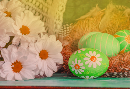 Easter eggs with spring flowers on tableの写真素材