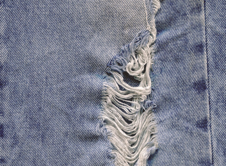 Closeup view blue natural clean denim texture. Texture of jeans textile close up. Blue torn jeans...