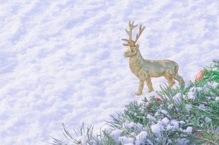 Golden deer figure on white snow. Christmas golden deer with snow.の写真素材