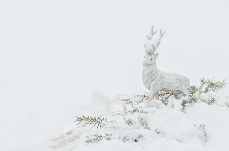 Silver reindeer toy. Silver grey shiny Christmas reindeer at white snow background.  の写真素材
