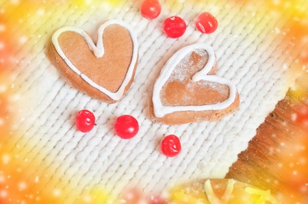 Love concept with red berries out in the form of heart  and  cookies in the form of heart  on a white tied background. Ripe red berries  and  cakes on a wooden backgroundの写真素材