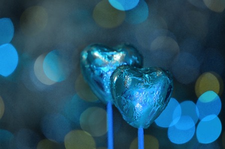 Red chocolate hearts wrapped in blue foil for Valentine's Day. Stack of chocolate heart の写真素材