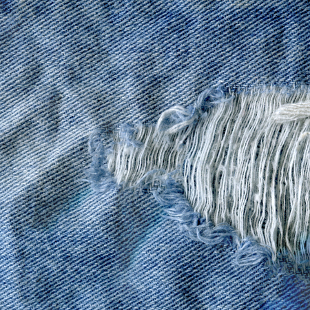 Blue torn grunge denim jeans texture. Jeans bit torn