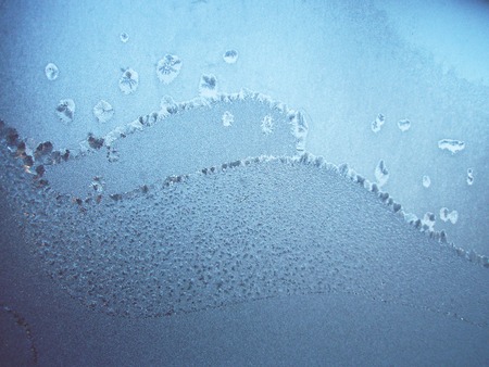 Winter ice patterns on glass. Frost patterns on window in winter. Winter frozen window glassの写真素材