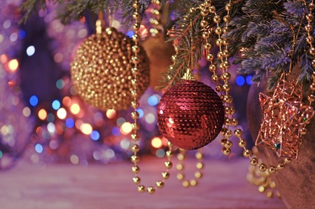 Red bauble on Christmas tree. Decorated Christmas tree. Red decorative ball on Christmas treeの写真素材