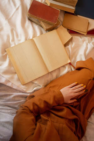 Woman reading book. Woman relaxing and reading book in bedの写真素材