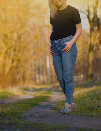 Woman walking on spring forest. Walking in the spring park. Beautiful young woman walking through the spring forest.の写真素材