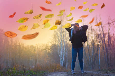 Tired woman in  yawns and covering her mouth. Tired of everything. Bored woman in the autumn parkの写真素材