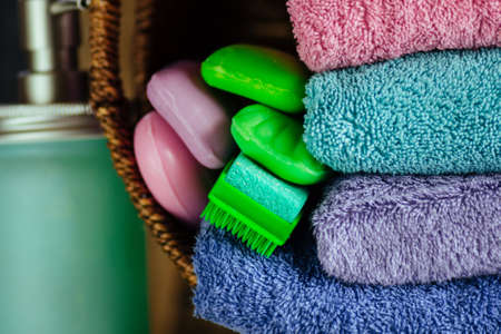 Stack of  towels, soap, washcloth, gel. Stack of bath towels on wooden background