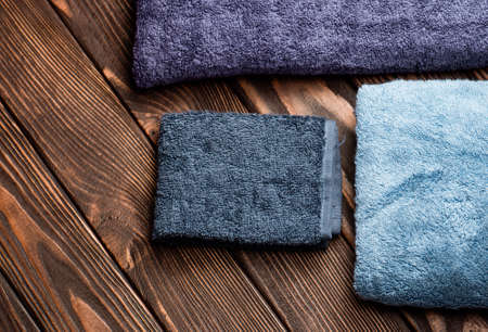 Bath towels on wooden background. Blue bath towel