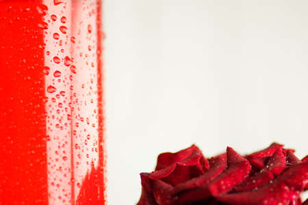 Pink rose flower and glass of rose water. Fresh organic rose water. Rose water in glass bottleの写真素材