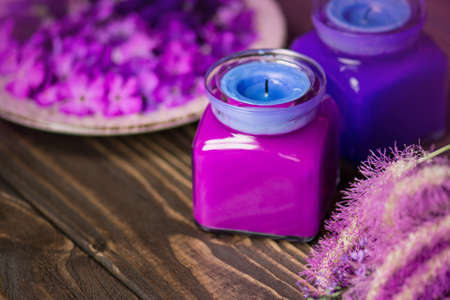 Violet and blue candles on a wooden backgroundの写真素材