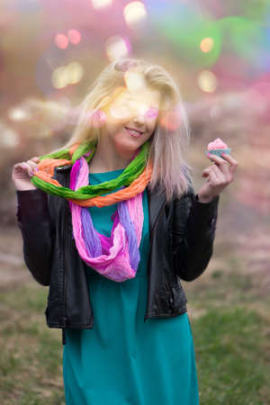 Romantic lady eating colorful cake. Funny girl eating dessert with pleasure during photoshootの写真素材