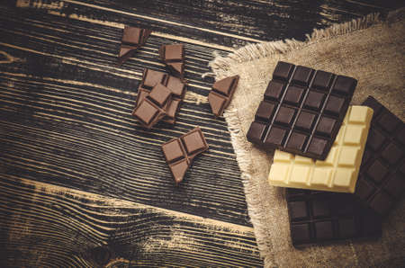Group of chocolate bars different colors. Different kind assorted sweets. Assorted chocolate on rustic wooden backgroundの写真素材