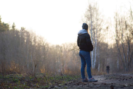 Woman walking on spring forest. Walking in the spring park. Beautiful young woman walking through the spring forest.の写真素材