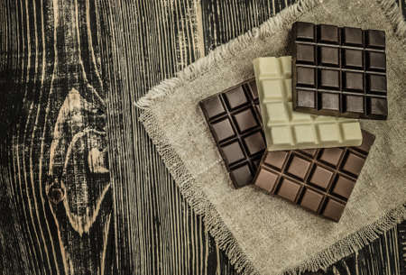 Dark, milk and white comemade chocolate factory background. Delicious chocolate pieces. Different mix chocolate bars.の写真素材