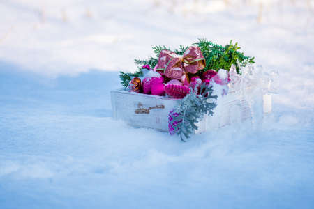 Christmas balls in a wooden box outdoors. Beautiful Christmas decorations. The concept of New Year and Christmas holidays.の写真素材