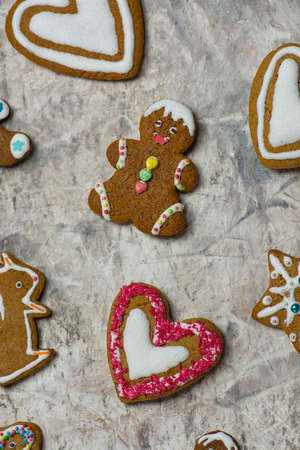 Christmas tasty gingerbread cookies on wooden background. Biscuits with sugar glaze on wooden background in decorated room.の写真素材