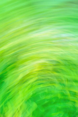 Green art blurred bokeh sparks flying background with motion effect. Green abstract flowing light trails effect. Green dynamic curving light trails.の写真素材