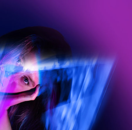 Young energetic girl on bright neon colors background dancing excitedly at home party. Happy pretty girl dancing on modern glowing colorful bright neon color backdrop.の写真素材