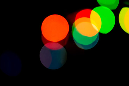 Light neon abstract lamps on black background blurry effect. Rainbow neon prism bokeh backdrop.の写真素材