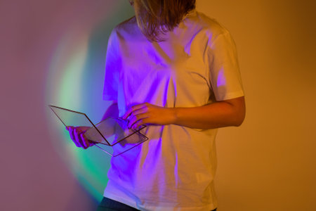 New era of neon bright minds at work. Beautiful young woman with digital tablet on modern technology lights background.の写真素材