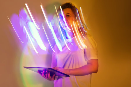 Stylish work with digital tablet in neon hues. Stylish young woman in white shirt with digital...