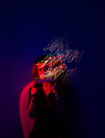 Master of the nail service in a professional uniform with nail files in the hands poses at a creative photo shoot in the studio.の写真素材