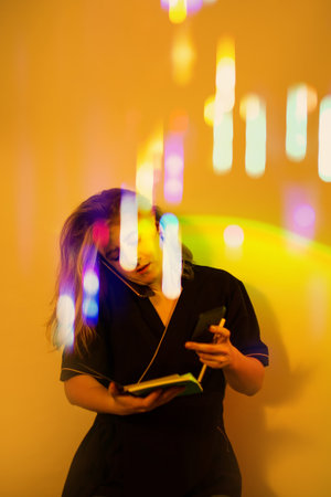 Excited beauty therapist masseuse resolves work issues using two phones.Portrait of woman masseuse uses two phones to communicate with customers.の写真素材