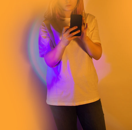 Happy woman holding a smartphone and receiving a new message on a neon glowing background. Text...