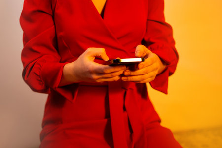 Excited young lady holding trendy smartphone. Beautiful and cute girl using smartphone.の写真素材