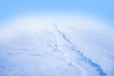 Abstract bright snowy background with copy space. Winter garden background with snow drifts. White snow texture.の写真素材