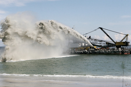 Dredging , panning sand on the beach during the construction of a new sea freight terminal in the harbor of Portのeditorial素材