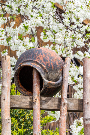 Related structure twigs and sticks in a vintage wooden rural fence with creative household items - old clay pots for cooking as trendy abstract background for designの写真素材