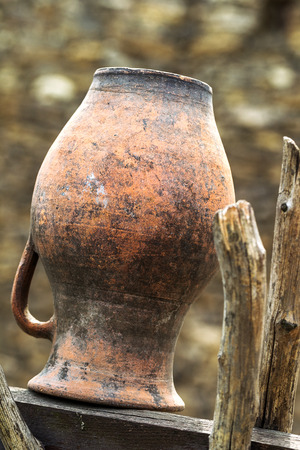 Related structure twigs and sticks in a vintage wooden rural fence with creative household items - old clay pots for cooking as trendy abstract background for designの写真素材