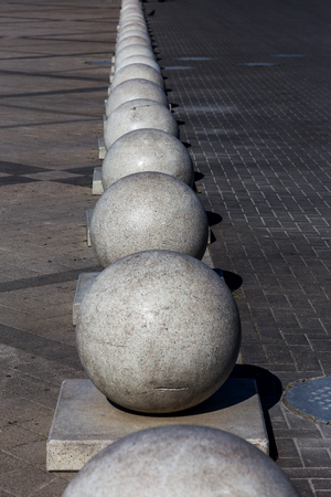 Stone balls on a city street. City design of the square. A ruler of large street decorative in large cracks of natural granite spheres. Cracks on the surface of a granite stone sphereの写真素材
