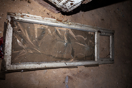 Broken glass in the windows of an old abandoned mystical house. A horror picture of broken window...